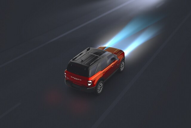 Overhead shot of the 2023 Ford Bronco® Sport SUV being driven in the dark with Auto High-Beam Headlamps lighting the way