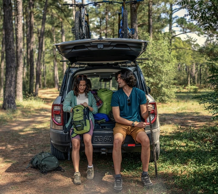 A woman and a man sitting in the back cargo area of a 2024 Ford Bronco® Sport SUV