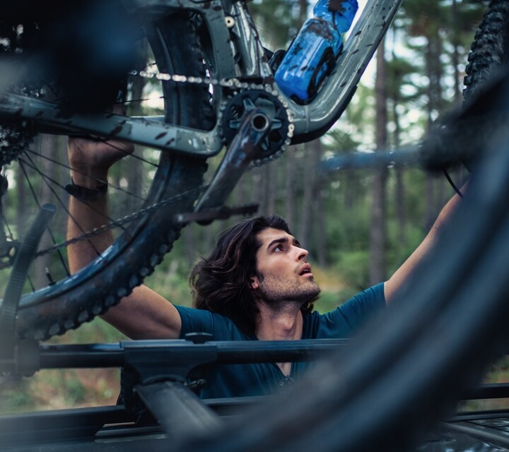 A man is securing his bike to the roof of the 2024 Ford Bronco® Sport SUV
