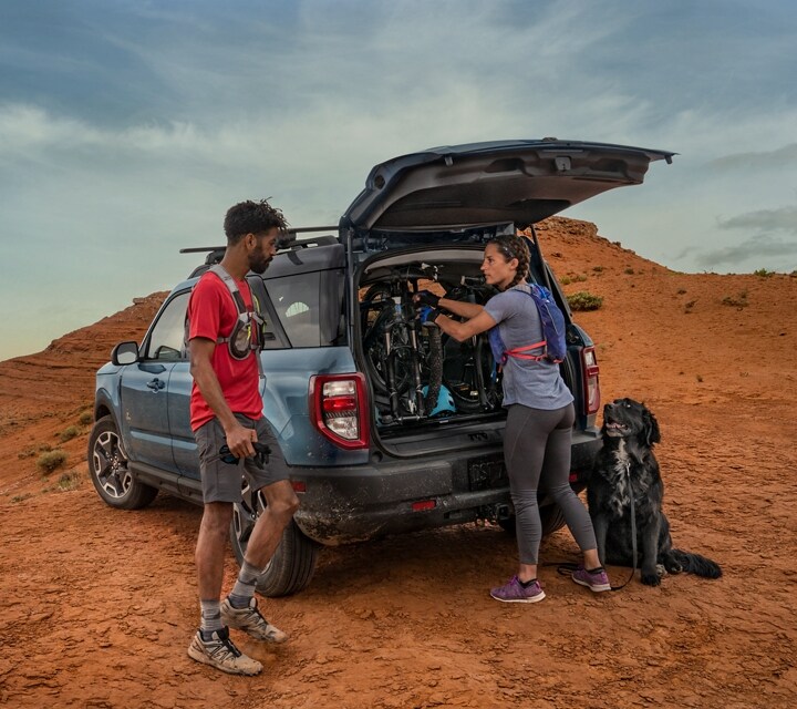 Two people standing outside a 2024 Ford Bronco® Sport SUV with cargo in the back