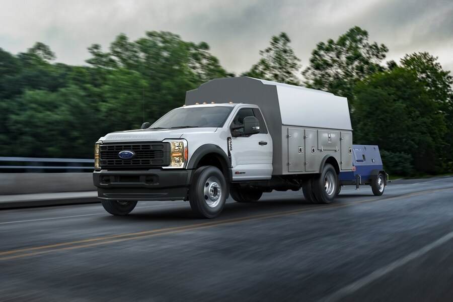 2023 Ford Super Duty® XLT being driven on a highway and pulling equipment