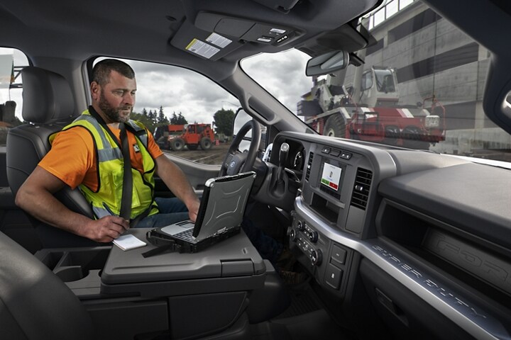 Worker using laptop inside a 2023 Ford Super Duty® Chassis Cab