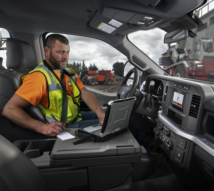 Worker using laptop inside a 2023 Ford Super Duty® Chassis Cab