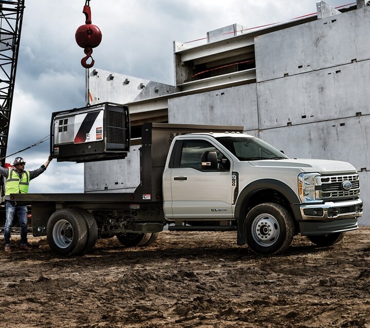 A 2025 Ford Super Duty® Chassis Cab on a construction site with equipment in the background