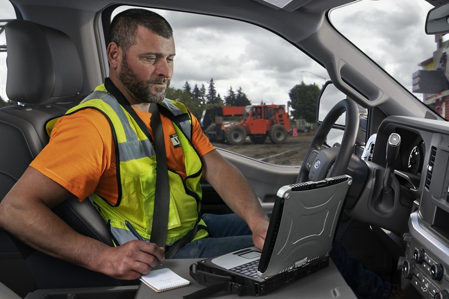 Interior of a 2025 Ford Super Duty® with a man working on a computer