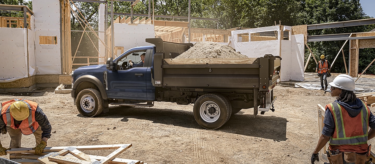A 2025 Ford Super Duty® F-550® XLT dump truck loaded with dirt on a job site