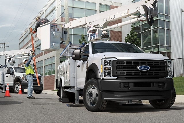2025 Ford Super Duty® F-350® with a bucket upfit with a worker grabbing material from another worker