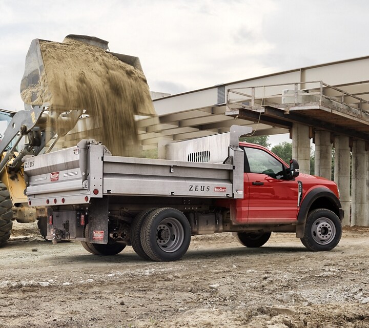 2025 Ford Super Duty® F-550® XL with a dump bed being filled with dirt
