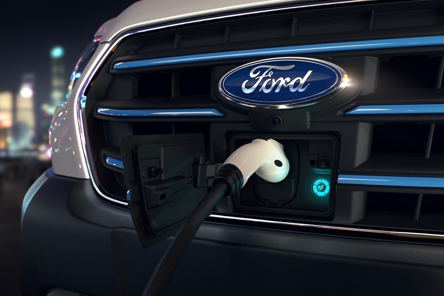 Close-up of the 2023 Ford E-Transit™ van grille with the charge cord plugged in