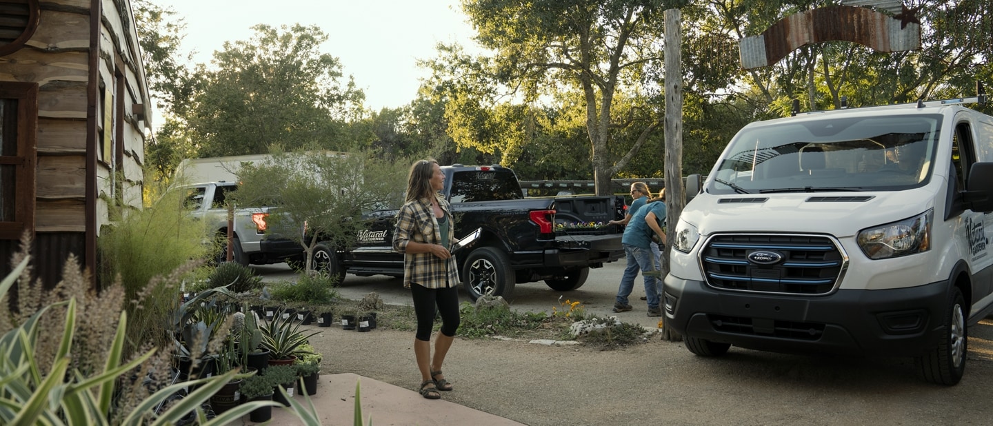 2023 Ford E-Transit™ Van parked in driveway with woman standing near it