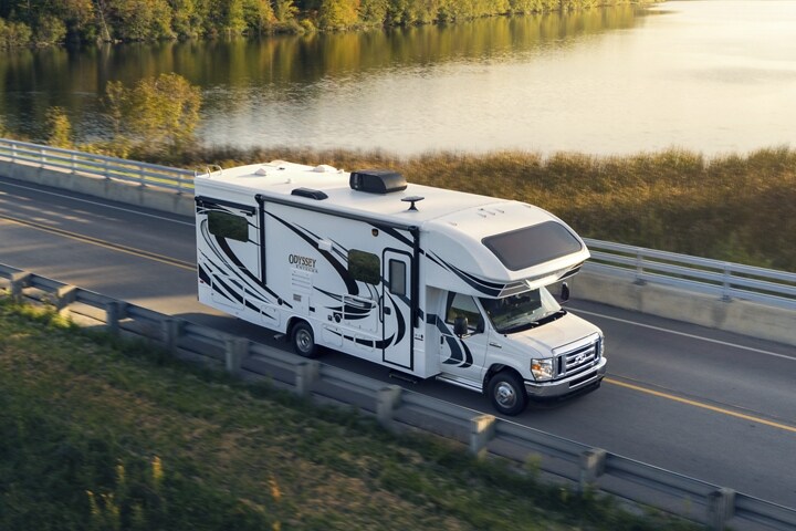 2024 Ford E-Series dual-rear-wheel Cutaway with Class C motorhome being driven near a large body of water
