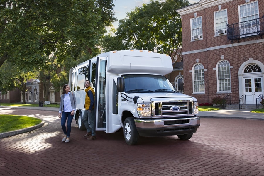 People getting out of a 2025 Ford E-Series Cutaway with shuttle bus body
