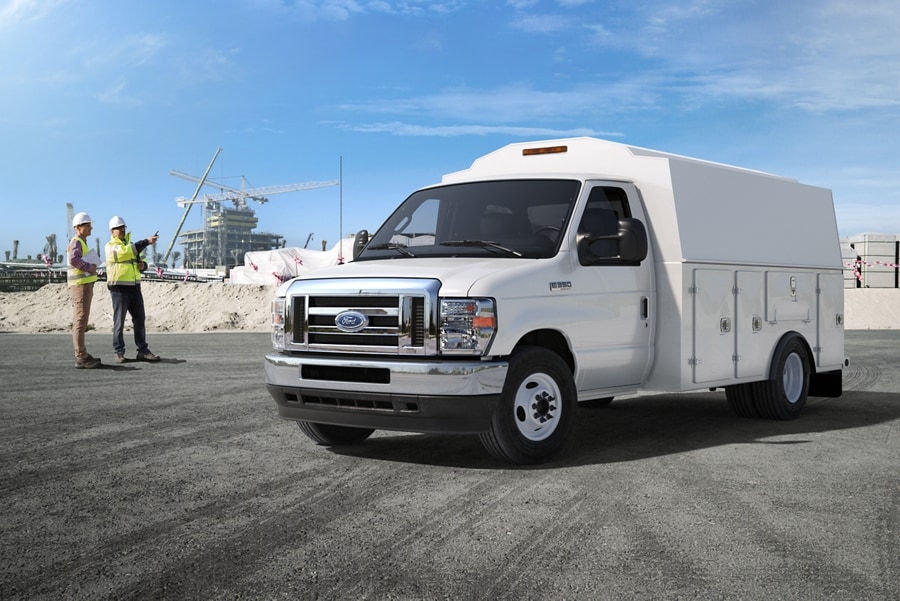 Two construction workers near a 2025 Ford E-Series Cutaway with contractor body upfit