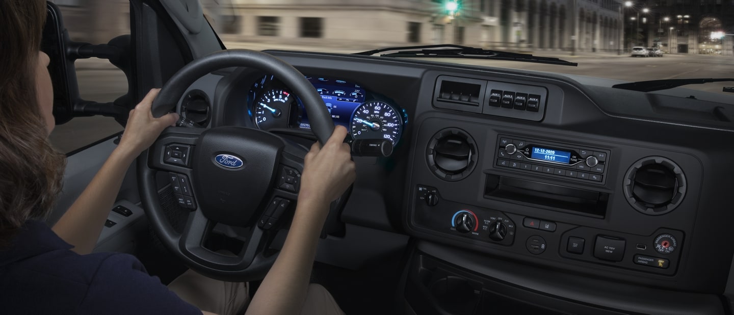 A woman driving a 2026 Ford E-Series Cutaway
