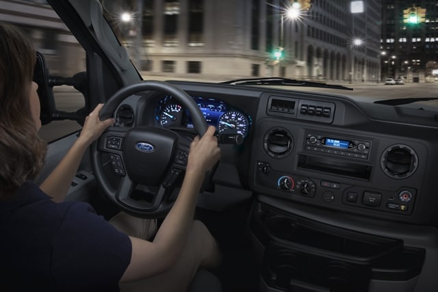 A woman driving a 2026 Ford E-Series Cutaway