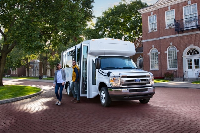People getting out of a 2026 Ford E-Series Cutaway with shuttle bus body