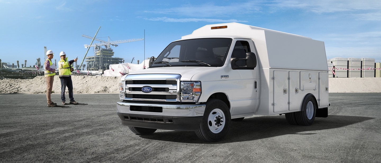 Two construction workers near a 2026 Ford E-Series Cutaway with contractor body upfit