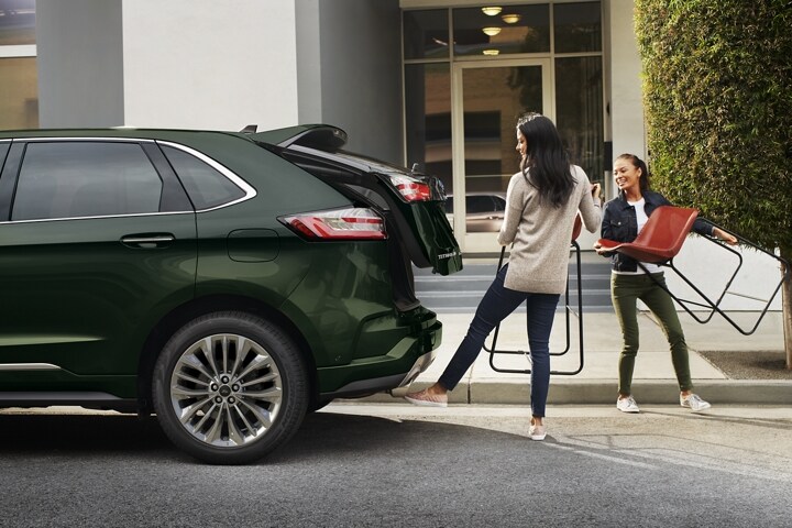 A woman swipes her foot under the bumper, activating the hands-free liftgate
