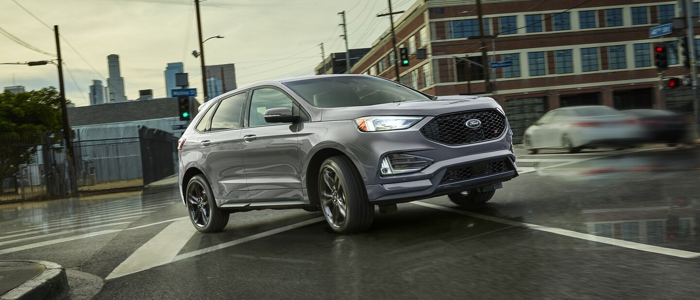2023 Ford Edge® SUV in Iconic Silver being driven on a wet city street