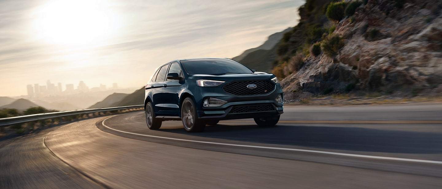2023 Ford Edge® ST in Stone Blue being driven on a mountain curve