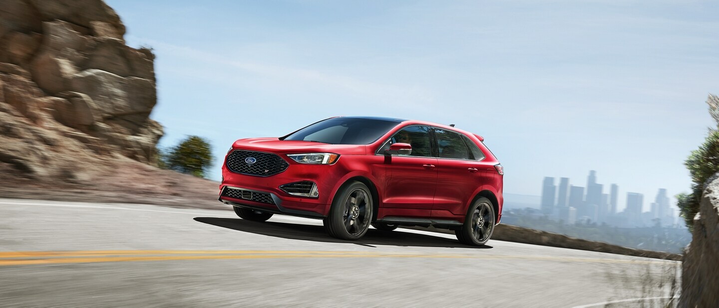 A 2024 Ford Edge® ST in Rapid Red being driven on a mountain road