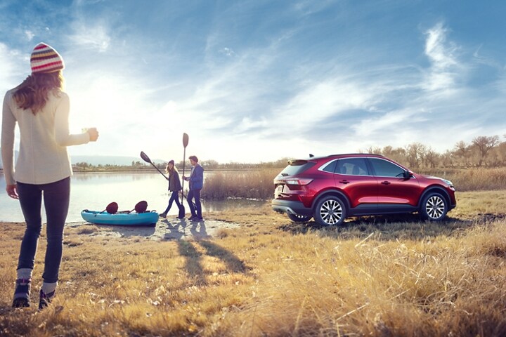 2022 Ford Escape Titanium in Rapid Red Metallic Tinted Clearcoat with a group of people boating by a lake