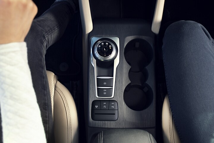 Interior of a 2022 Ford Escape with a view of the rotary gear shift dial and cupholders