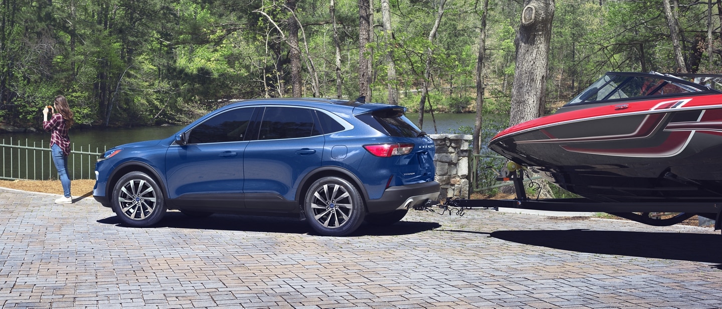 2022 Ford Escape in Atlas Blue Metallic towing a boat on a trailer
