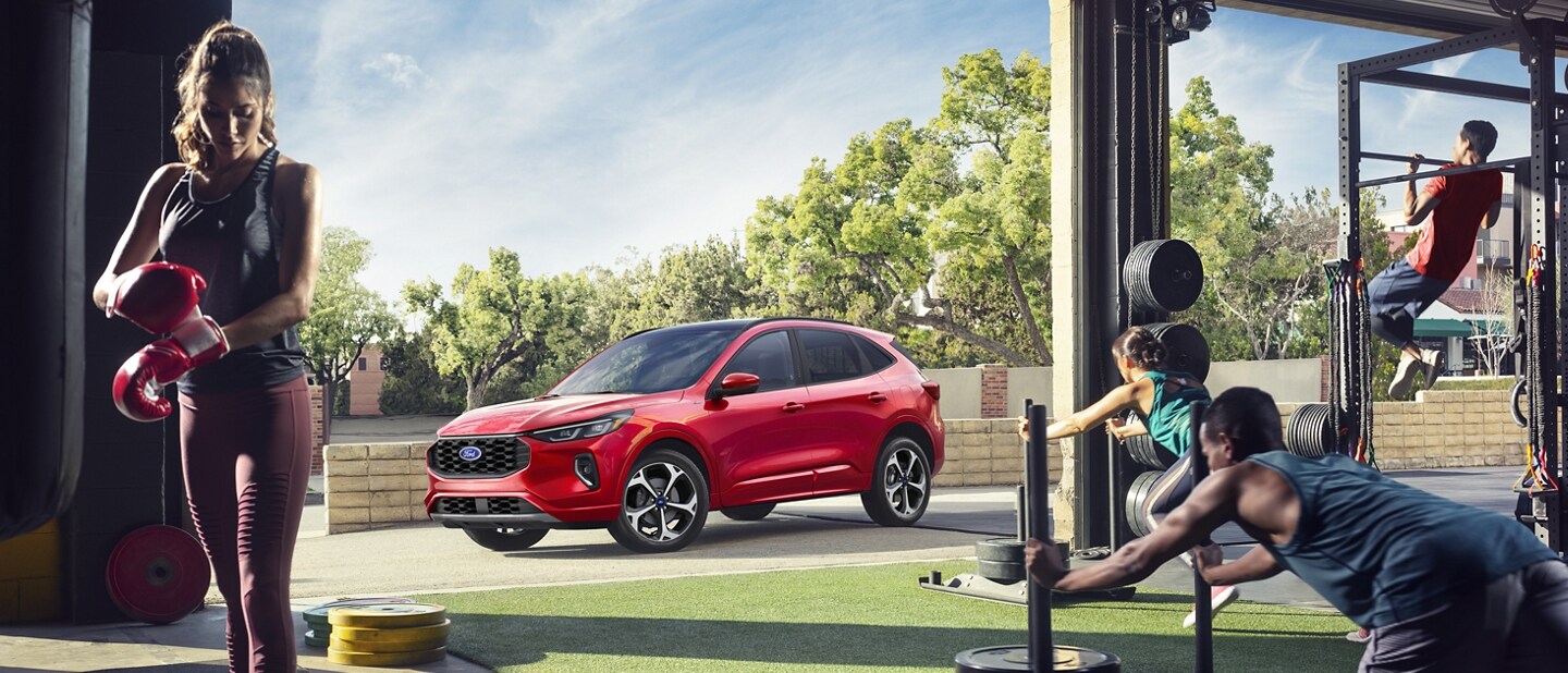 2023 Ford Escape® in Rapid Red Metallic Tinted Clearcoat (extra cost paint) parked outside a busy fitness center