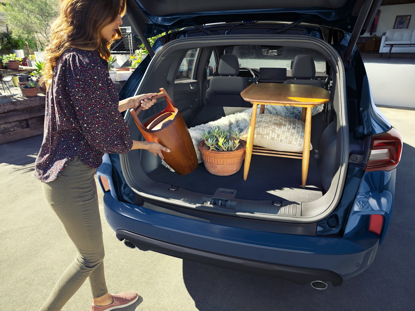 Person loading items into the spacious rear cargo area of a 2023 Ford Escape®