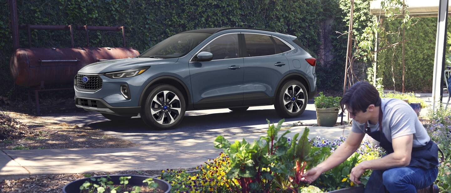 2023 Ford Escape® in Vapor Blue Metallic parked in garden with man attending plants