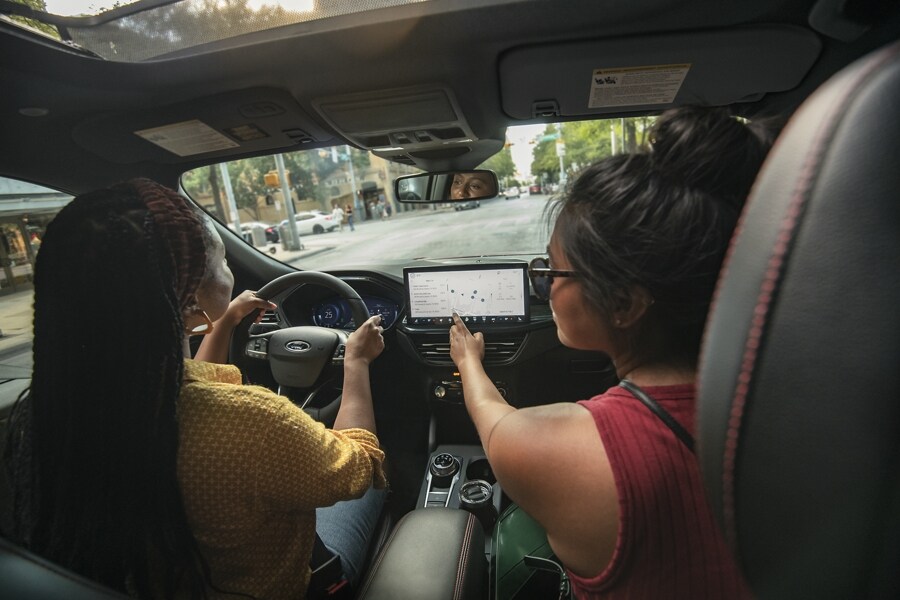 Interior of a 2023 Ford Escape® as passenger interacts with the touchscreen