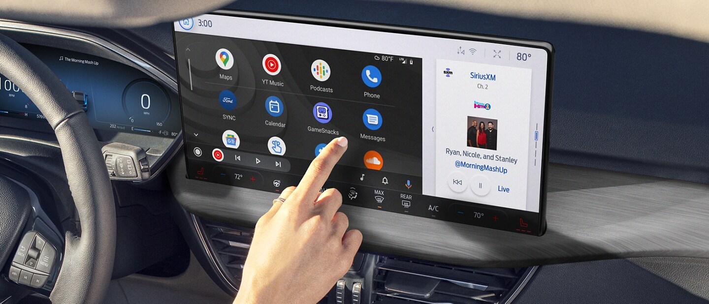 A woman seated in a 2024 Ford Escape® interacting with icons on a dash-mounted touchscreen