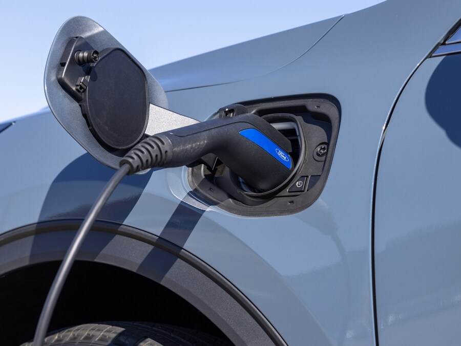 Close-up view of a charging cable plugged into the charge port of a plug-in hybrid 2024 Ford Escape®