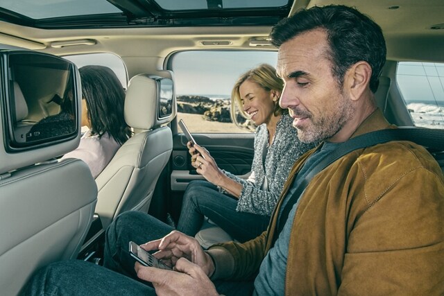 People in second row of 2021 Ford Expedition Platinum using their smartphones