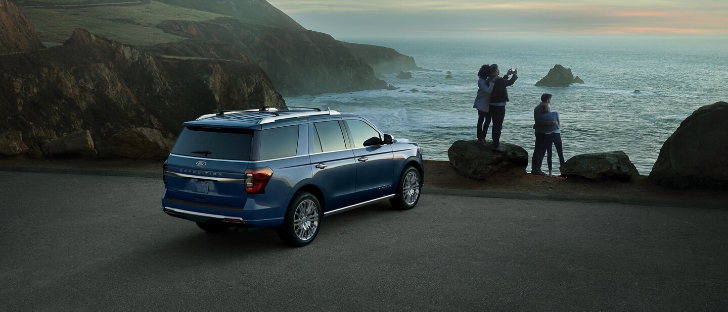 People taking photos of a body of water next to a 2023 Ford Expedition SUV