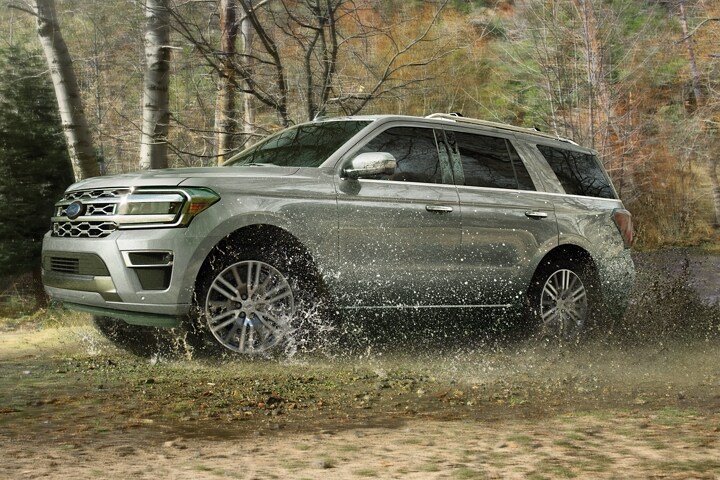 A 2023 Ford Expedition SUV being driven through wet grass