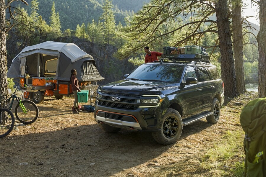 A 2023 Ford Expedition SUV parked at a campsite in the woods