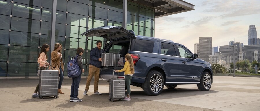 A family loading luggage into the rear of a 2023 Ford Expedition SUV
