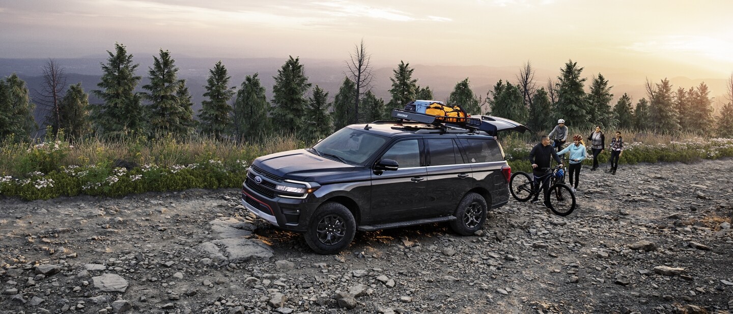 A 2023 Ford Expedition SUV parked on a rocky road near a body of water