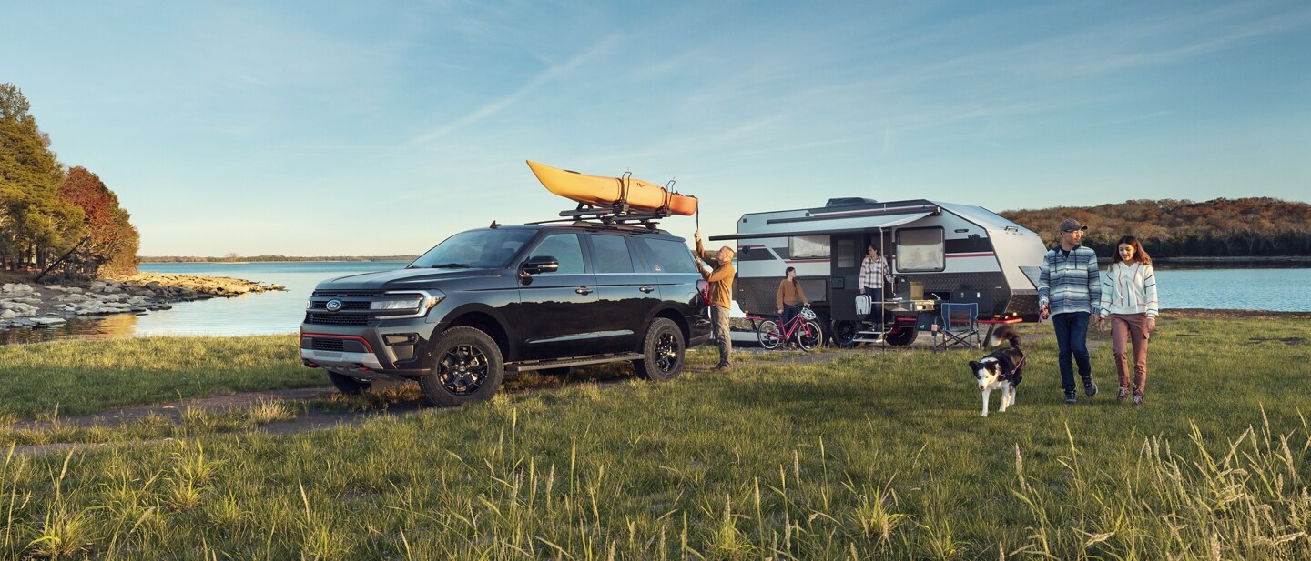 A 2023 Ford Expedition SUV parked at a campsite near a lake