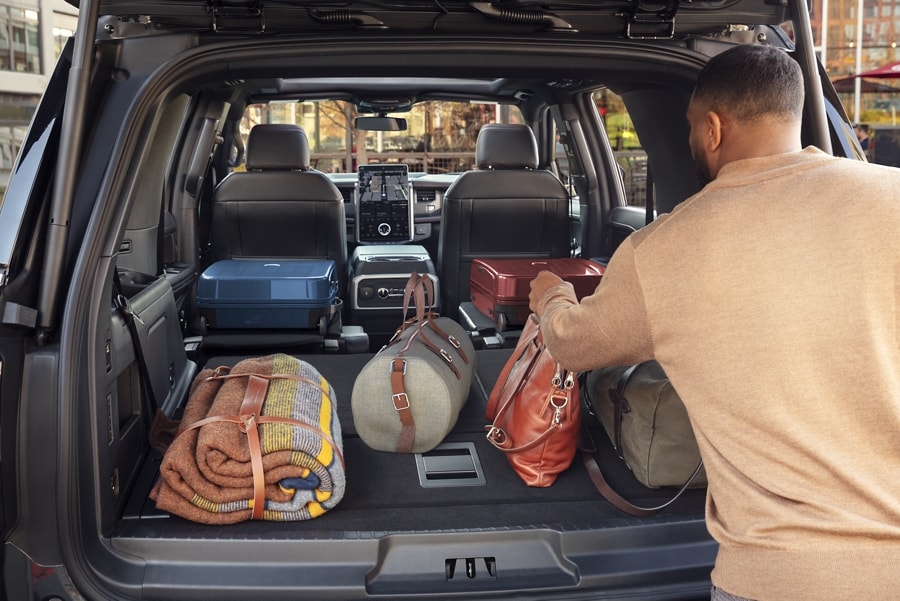 A man placing cargo in the back of a 2023 Ford Expedition SUV