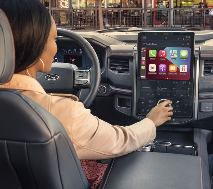 A woman using the touchscreen in a 2023 Ford Expedition SUV