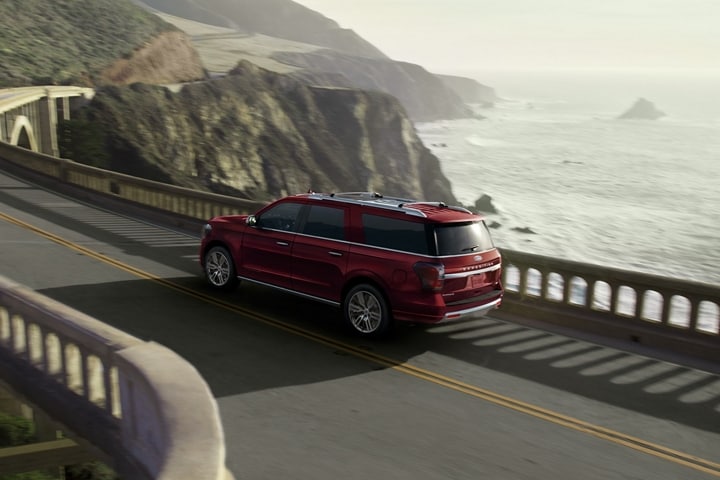 A 2023 Ford Expedition SUV driving across a bridge on a mountain road