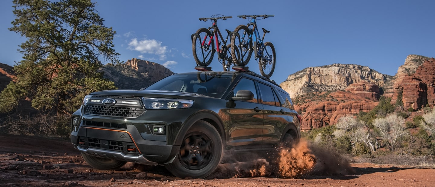2023 Ford Explorer® Timberline® model being driven through the desert with bikes on the roof