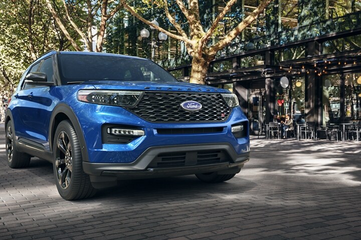 2023 Ford Explorer® ST model in Atlas Blue Metallic parked next to a cafe in a city environment