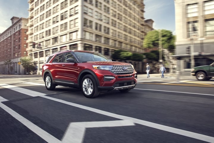2023 Ford Explorer® Limited SUV in Rapid Red Metallic Tinted Clearcoat (extra cost colour option) being driven on a street