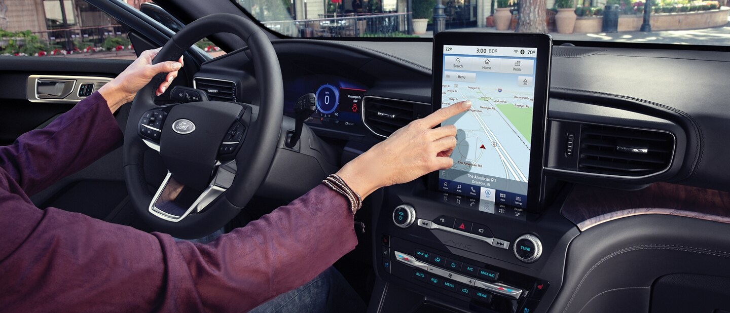 2023 Ford Explorer® SUV with the driver using the touchscreen