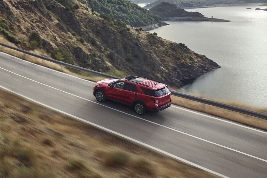2023 Ford Explorer® ST Line model being driven on a lakeside highway