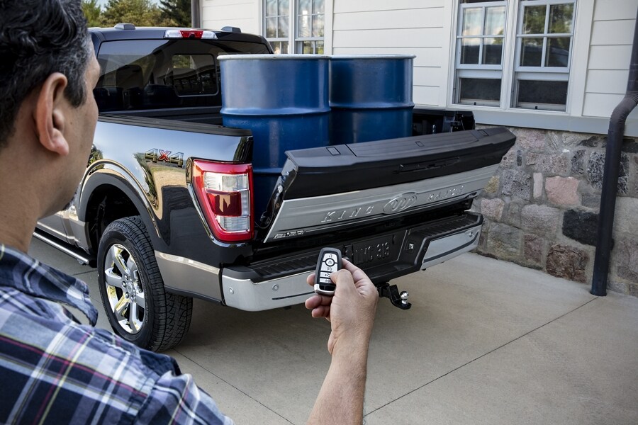 A person using their key fob to operate the power tailgate on a 2021 Ford F 1 50 